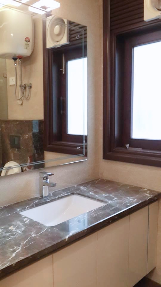 Marble-clad bathroom with wall-hung WC, vessel sink and frameless glass shower — Bathroom 1, Green Park Residence