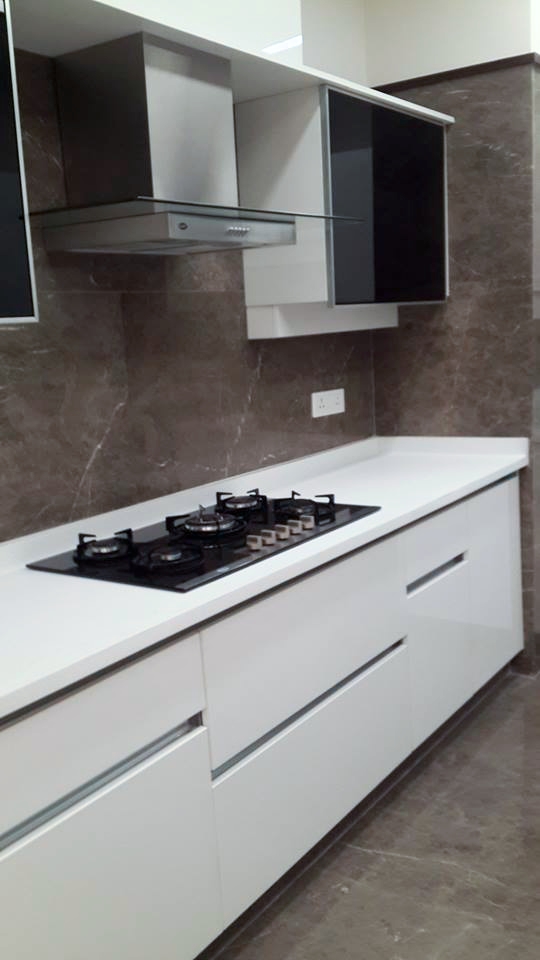 Modular kitchen run with dark marble backsplash, light-tone base cabinets and built-in chimney — Green Park Residence
