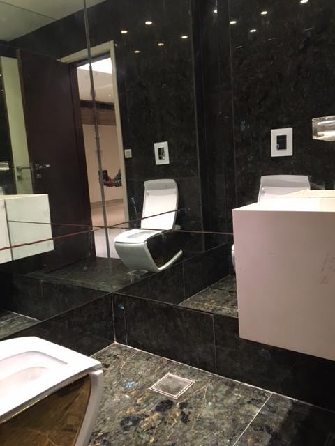 Bathroom 3 — Travertine with warm earth tones, vessel sink and rainfall shower — Maharani Bagh Residence