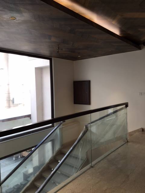 Custom glass and steel staircase with open risers and frameless glass balustrade — Maharani Bagh Residence
